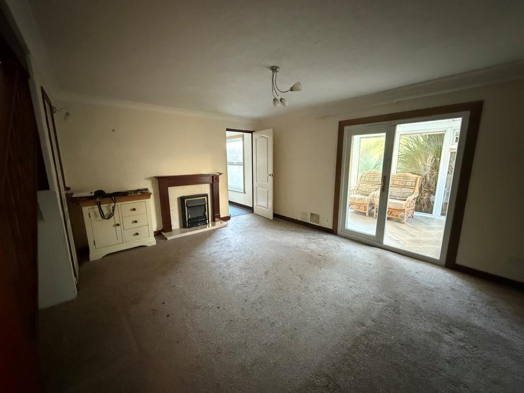 Lot: 141 - DETACHED FOUR-BEDROOM HOUSE FOR IMPROVEMENT - Carpeted lounge with doors to conservatory and dining